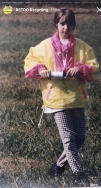a girl in a yellow jacket holding a bat