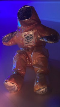 a stuffed animal in a space suit sitting on a table