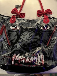 a black and red bag with a tiger on it