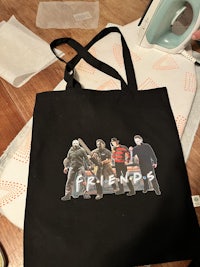 a black tote bag with a picture of a group of people